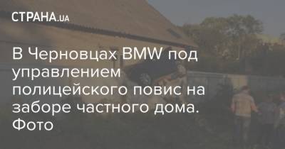 В Черновцах BMW под управлением полицейского повис на заборе частного дома. Фото