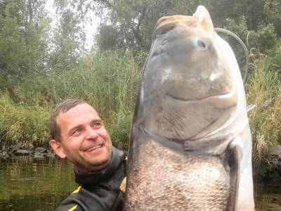 Рыбаку из Днепра удалось выловить гигантского толстолобика в человеческий рост