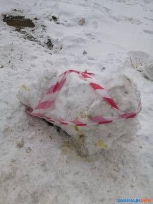В Южно-Сахалинске приоткрытый люк закрыли глыбой снега с ленточкой