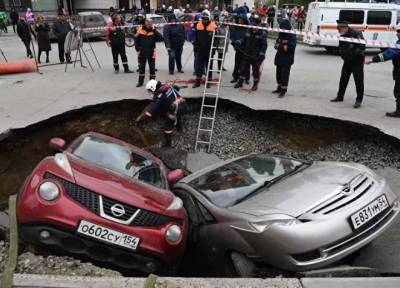 На автостоянке в Новосибирске две иномарки провалились в яму с кипятком