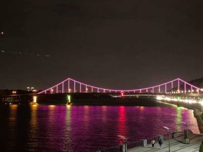 В Киеве пешеходный мост через Днепр засиял розовим светом