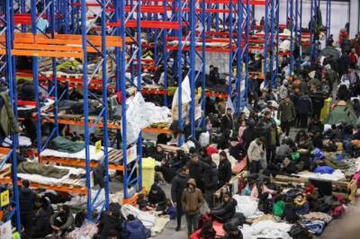 Фото дня: Мигранты спят на стеллажах для товаров в логистическом центре на границе Беларуси