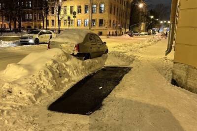 Дорожники залатали яму на заснеженной дороге в центре Петербурга