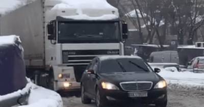В Киеве водитель люксового автомобиля помог выбраться фуре из снега (видео)