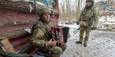Громкая тишина. Украинский военный играет на аккордеоне возле линии разграничения на Донбассе — фото дня