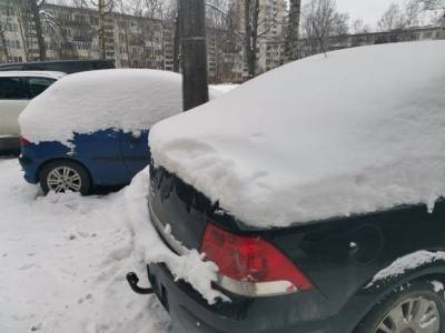 В Петербурге рабочие счистили снег с крыши дома на припаркованную машину