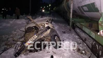 В Киеве на переезде товарный поезд врезался в ВАЗ, пассажира вырвало из салона и тянуло около километра