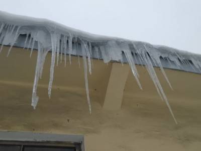 Петербургские коммунальщики сбрасывают снег и лед на крыши автомобилей, прикрытые картоном