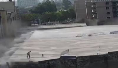 В Китае здание обрушилось под ногами стоявшего на крыше рабочего