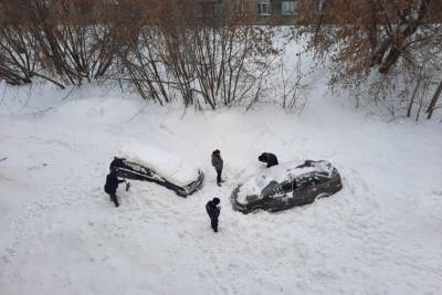 В Новосибирске лавина снега, сошедшая с крыши дома, повредила две машины