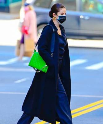 Со съемок на стритстайл: Селена Гомес в монохромном образе с неоновой сумкой Louis Vuitton