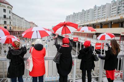 Фотофакт. Девушки под красно-белыми зонтами прогулялись по центру Минска