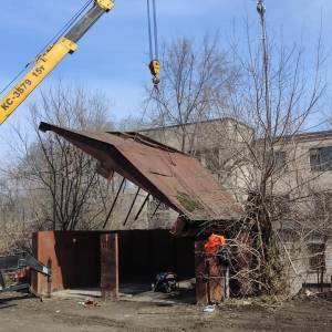 В Запорожье сносят металлический гараж с помощью подъемного крана. Фото
