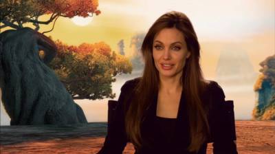 Раскованная Анджелина Джоли опасно наклонилась, едва не вывалив свое "богатство" из декольте: "Любим и хотим..."