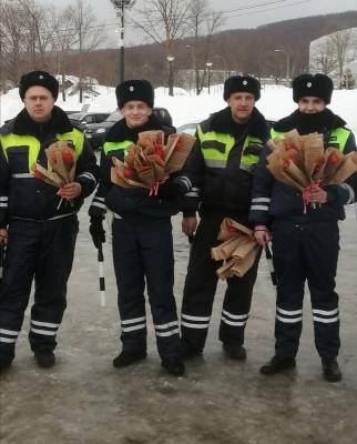 Сотрудники госавтоинспекции Сахалинской области дарят женщинам цветы