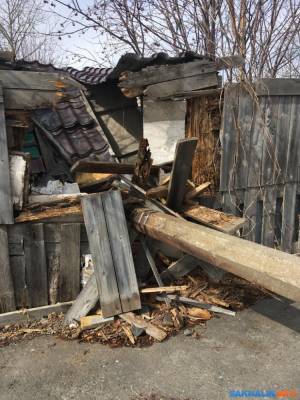 Упавший на сарай столб на Корсаковской в Южно-Сахалинске месяц никто не убирает