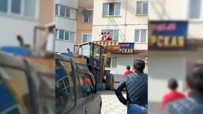 Сахалинские дорожники с помощью ковша эвакуировали жильцов горящего дома