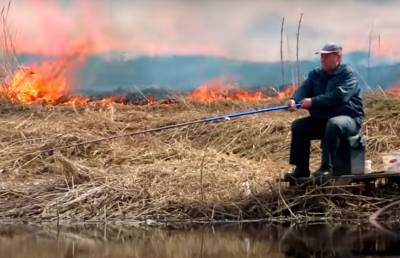 И пусть весь мир подождет! Белорус с невозмутимым видом продолжил рыбачить на фоне пожара и стал мемом