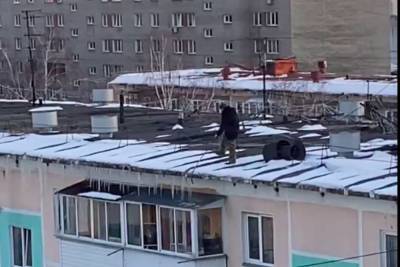 Мужчина без страховки сбивал лед с крыши пятиэтажки в Новосибирске