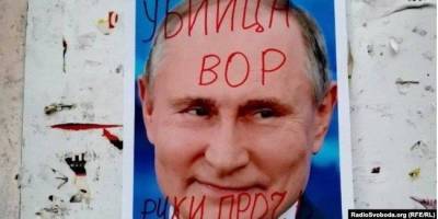 «Вор и убийца». В Беларуси неизвестные разрисовали и сожгли портреты Путина — фото, видео