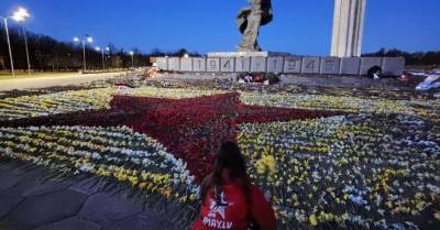 ФОТО: Волонтеры 9maijs.lv за ночь сложили из цветов звезду у подножия памятника в Риге