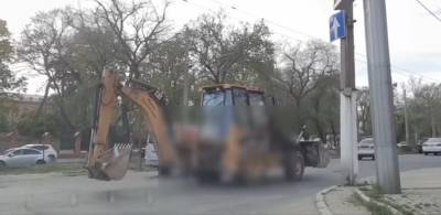 Курьез: в Одессе экскаватор передвигался по дороге при помощи ковша (видео)