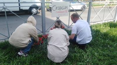 Жители Казани несут цветы к месту массового убийства в школе