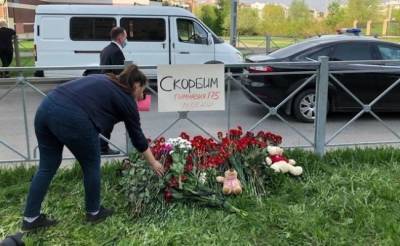 Жители Казани несут цветы к зданию школы № 175