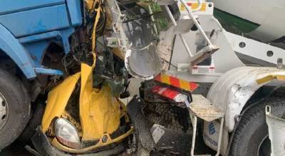На выезде из Киева два грузовика раздавили легковушку