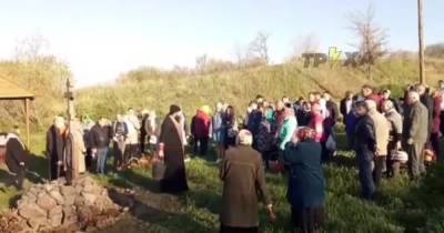 Прямо из ведра: в Харьковской области священник креативно подошел к освящение куличей (видео)
