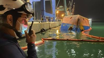 Водолазы ищут людей с перевернувшегося в порту контейнеровоза. Видео