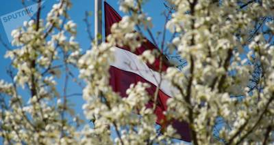 Публицист негодует: жительницу Риги попросили убрать флаг с балкона