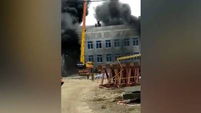 Крановщик спас рабочих, заблокированных на крыше горящей школы. Видео