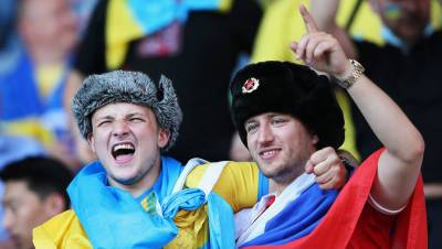 Болельщики с флагами России и Украины, обнявшись, болеют за украинцев на Евро