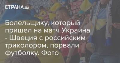 Болельщику, который пришел на матч Украина - Швеция с российским триколором, порвали футболку. Фото
