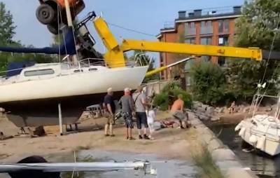 Видео: при спуске на воду автокран не удержал лодку, а потом упал на нее в Кронштадте