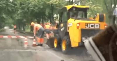 Киевских коммунальщиков заметили за дорожными работами во время ливня (видео)