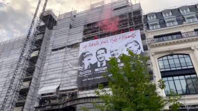 В Париже активисты закрасили витрины универмага и повесили баннер