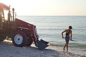 Коммунальщики прицепами вывозят мёртвых медуз с пляжей Кирилловки