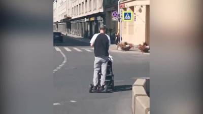 Видео: мужчина на мини-сигвее катил коляску по проезжей части в Петербурге