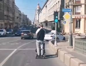 На проезжей части в Петербурге заметили мужчину на гироскутере с детской коляской