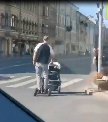 В Петербурге мужчина на гироскутере ехал по проезжей части, катя коляску с ребенком