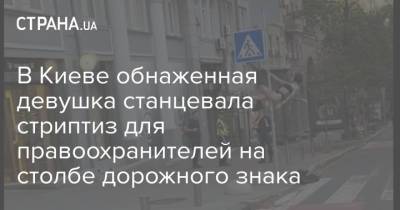 В Киеве обнаженная девушка станцевала стриптиз для правоохранителей на столбе дорожного знака