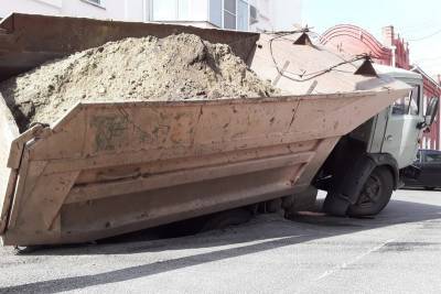В Кургане груженый песком КамАЗ провалился колесом под асфальт