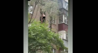 Спасатели сняли с козырька дома голого мужчину (видео)