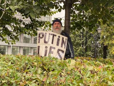 На акции коммунистов в Москве мужчина с плакатом «Putin lies» привязал себя к дереву