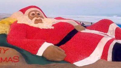 На пляжі в Індії створили гігантського Санта-Клауса з помідорів та піску (відео)