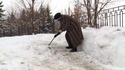 На Тепличной пенсионерка разбивает лед на лестнице клюшкой