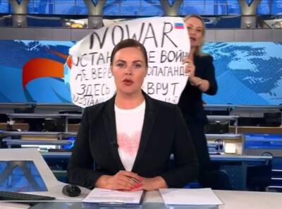 Девушка с антивоенным плакатом зашла в кадр во время выпуска новостей Первого канала