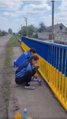 На Харьковщине местные жители красят мосты в цвета Государственного флага (видео)